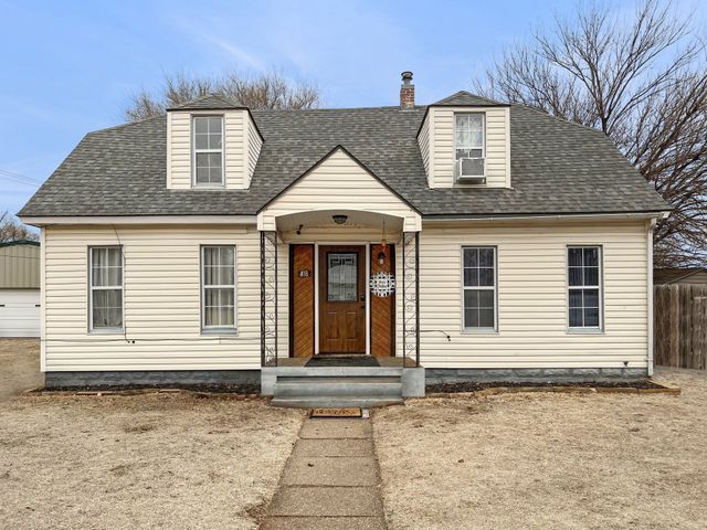 A white house with a gray roof and a brown door