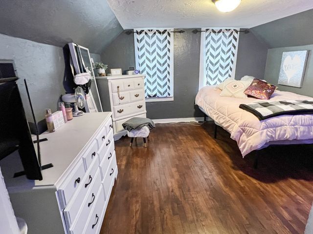 A bedroom with a bed , dresser , and television.