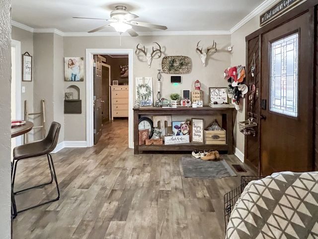 A living room with hardwood floors and a ceiling fan.