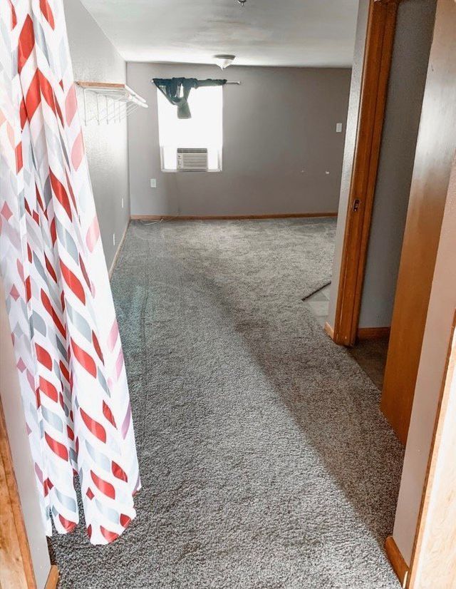 A hallway in a house with a shower curtain hanging on the wall.