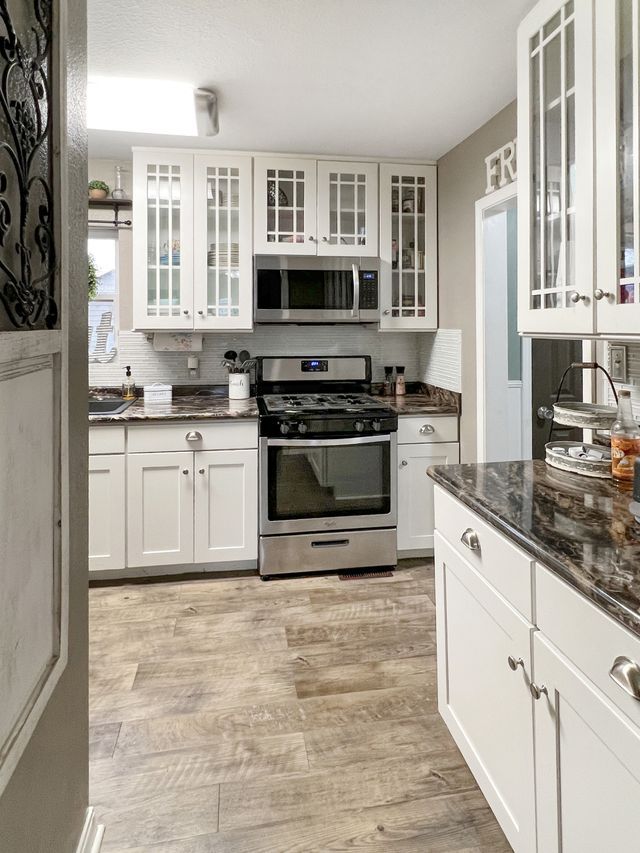 A kitchen with stainless steel appliances and white cabinets