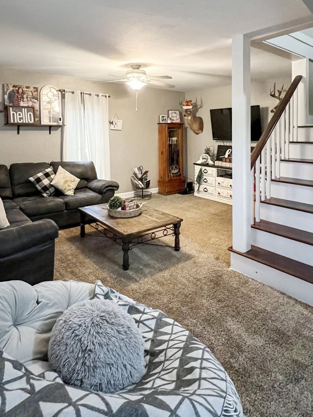 A living room with a couch , coffee table , and stairs.