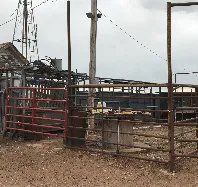 A fenced in area with a building in the background.