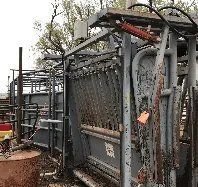 A metal fence is sitting on top of a dirt field.