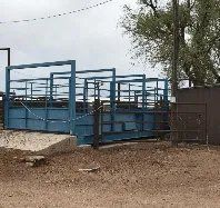 A blue fence is sitting in the middle of a dirt field.