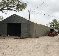 A large warehouse with a truck parked in front of it.