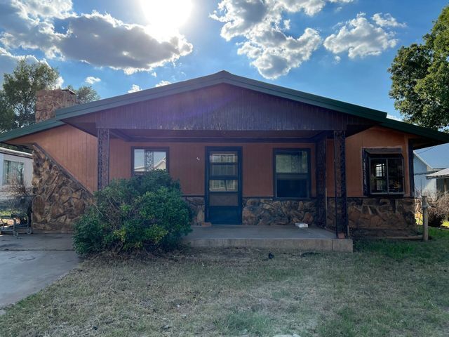 A house with a porch and a lot of windows is for sale.