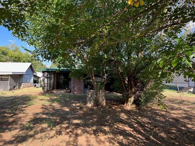 A house with a lot of trees in front of it.