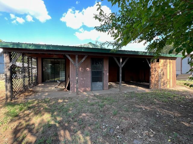 A brick house with a green roof and a covered porch