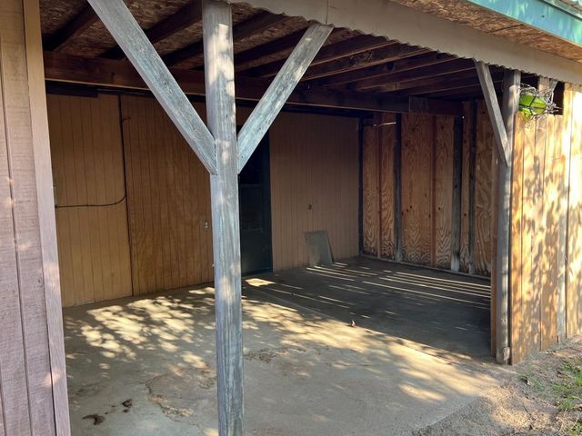 An empty garage with a wooden roof and a concrete floor