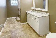 A bathroom with two sinks , a toilet , and a mirror.