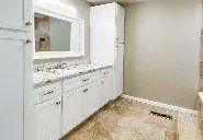 A bathroom with two sinks , a mirror and a tub.