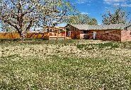 A house is sitting in the middle of a field of flowers.