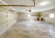 A large empty garage with a garage door opener.