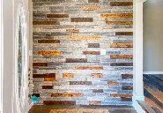 A hallway with a brick wall and a wooden floor.