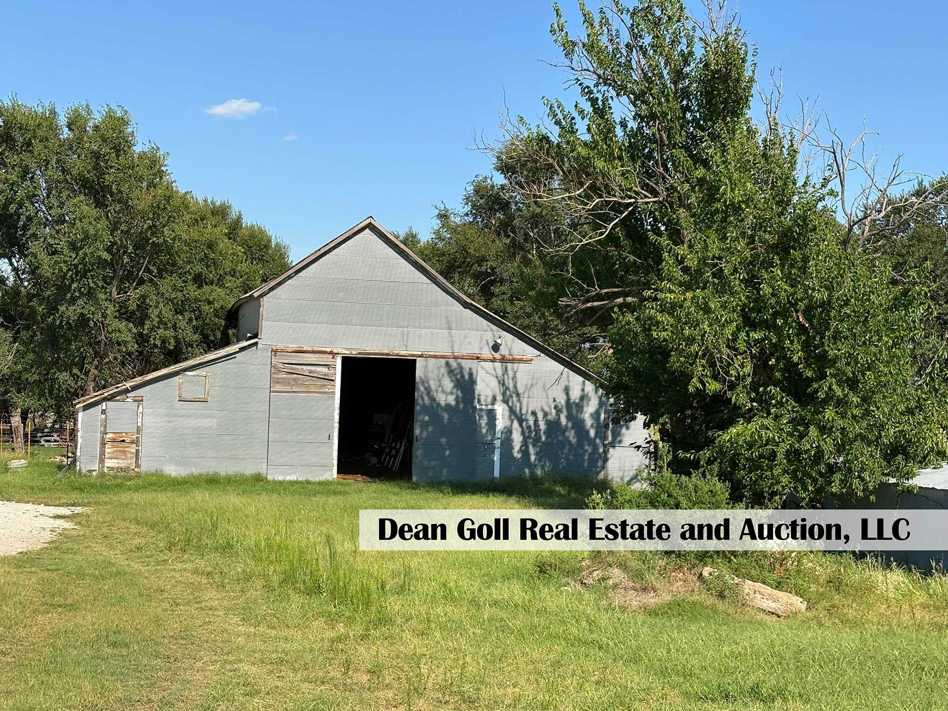 old, weathered metal barn with open door