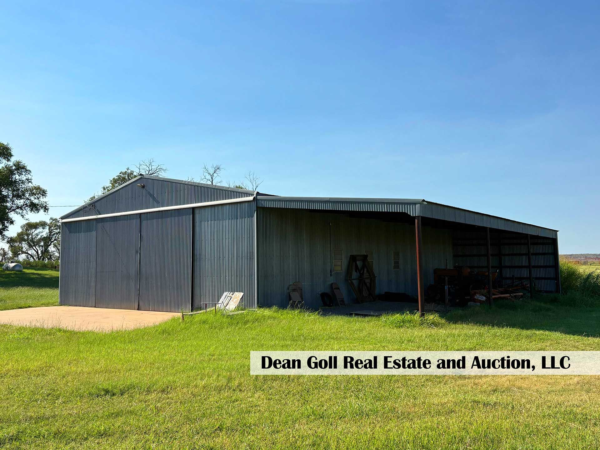 metal shed on a grassy field under a bright blue sky