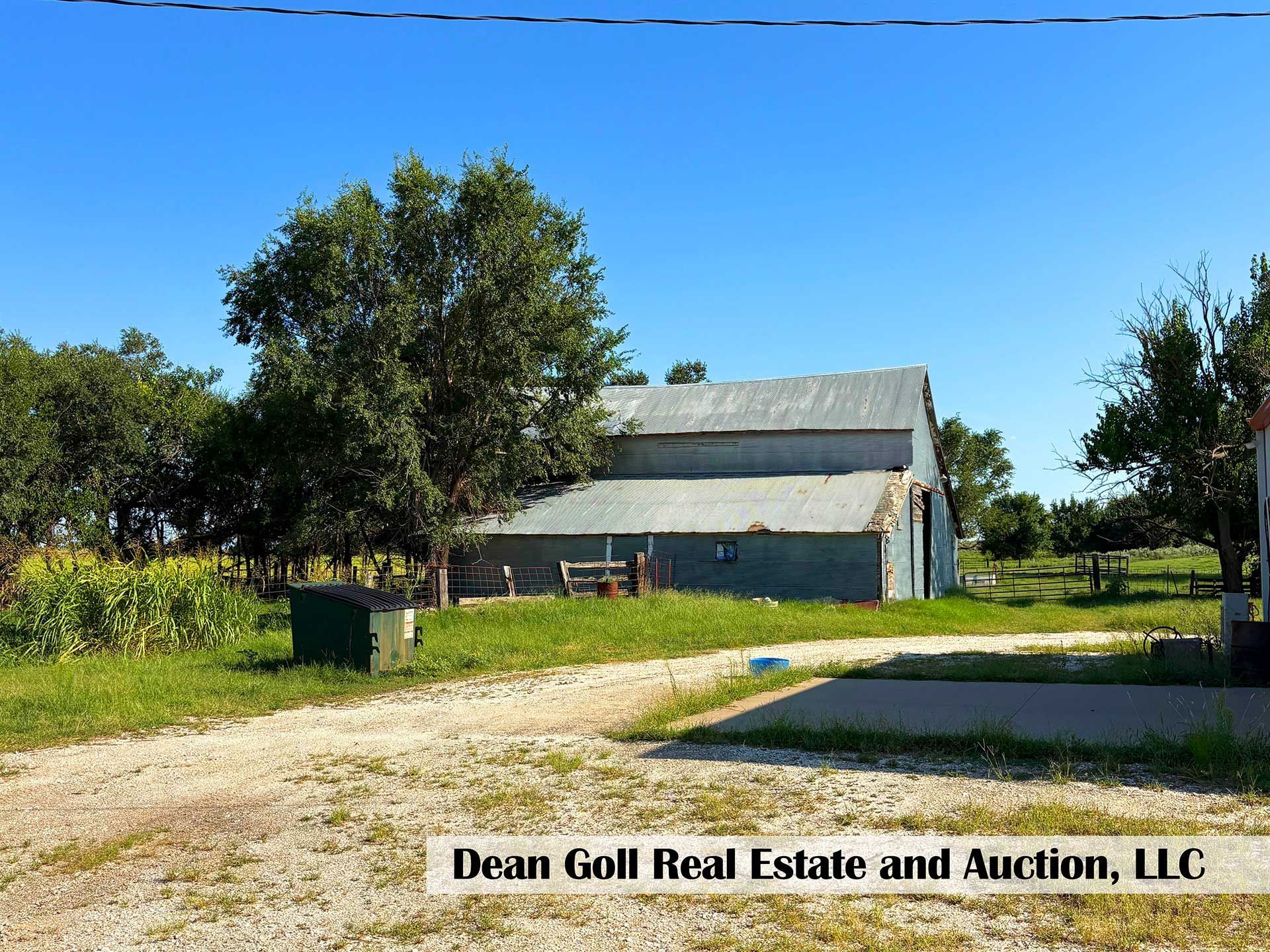 barn on a farm with a metal roof under a bright blue sky