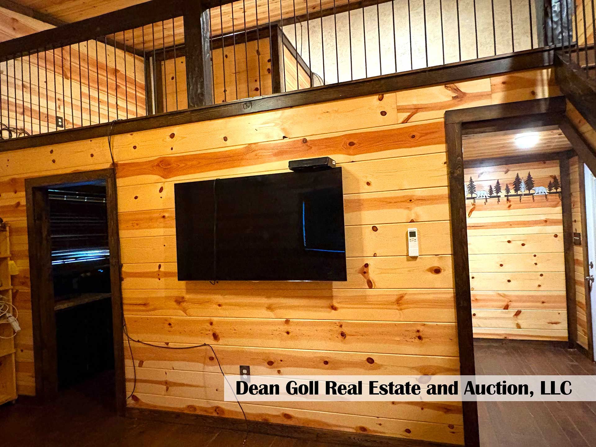wooden-walled room with a mounted TV and a loft