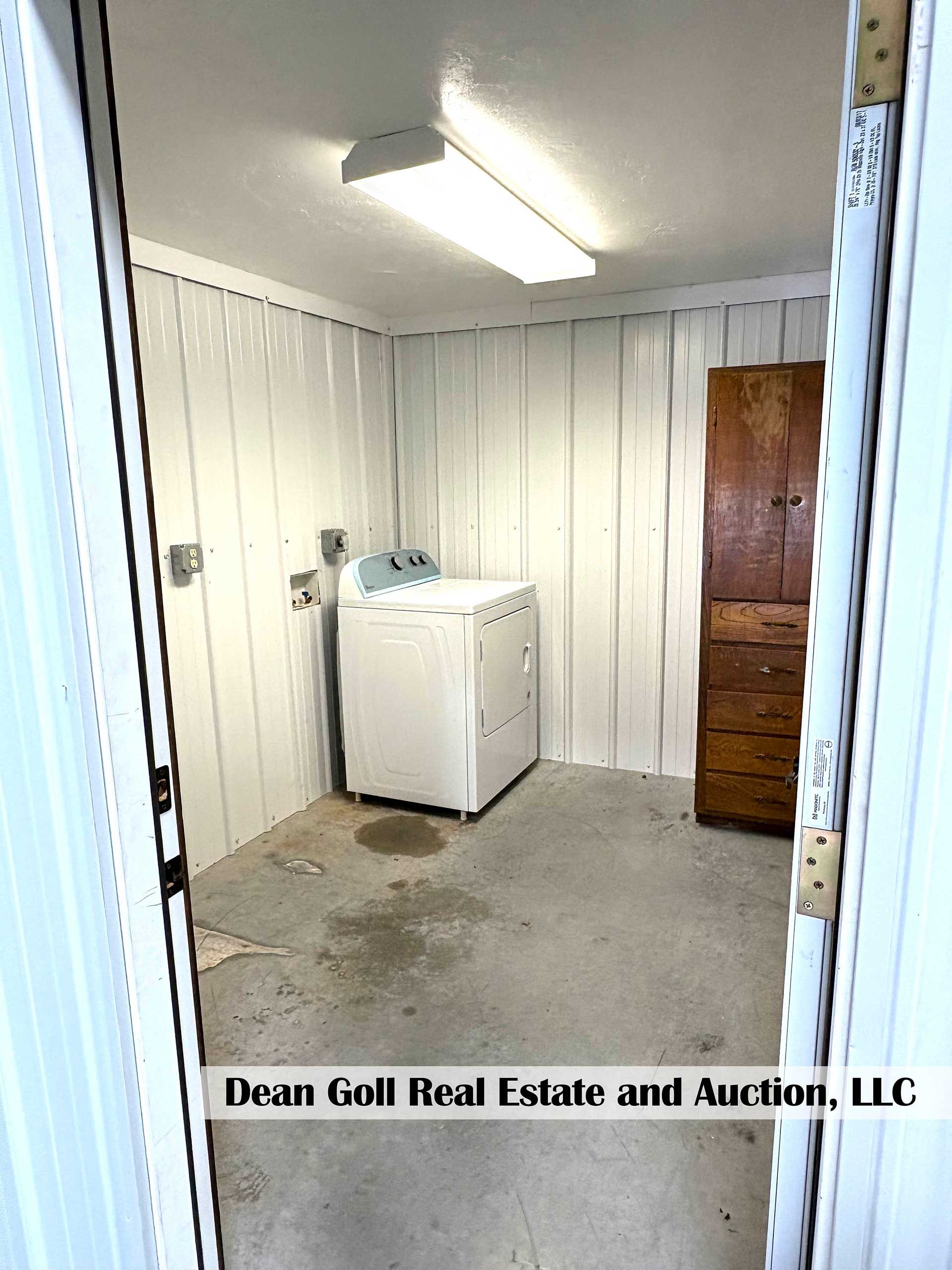 laundry room with white walls, washer, and tall wooden cabinet