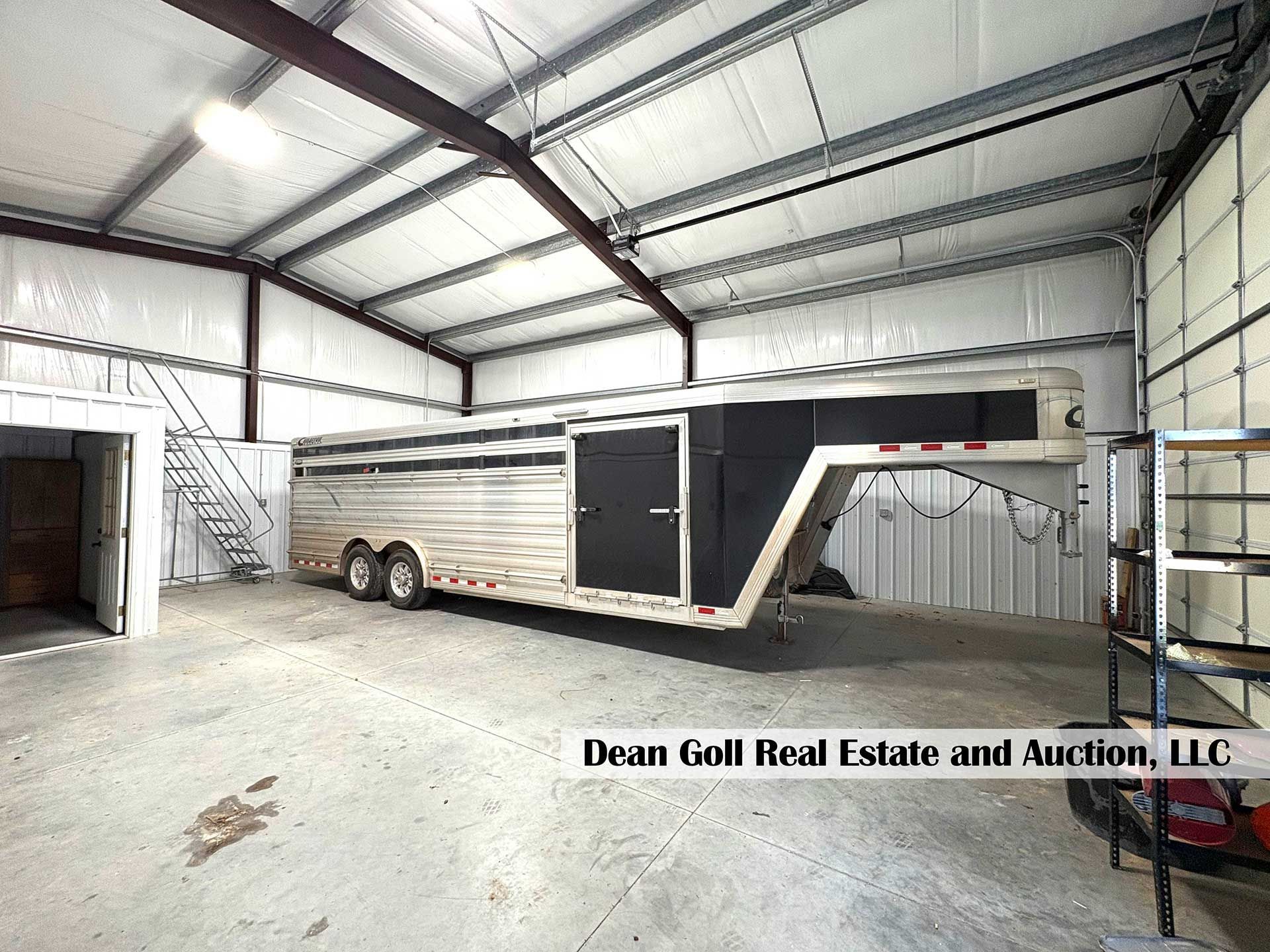 horse trailer inside a large metal building with a concrete floor