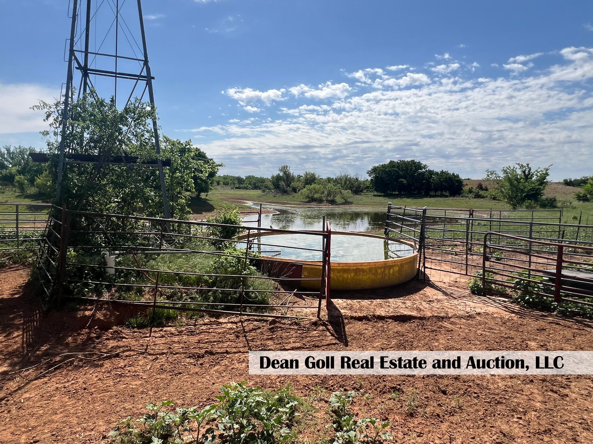A fenced-in area with a pond in the middle of it