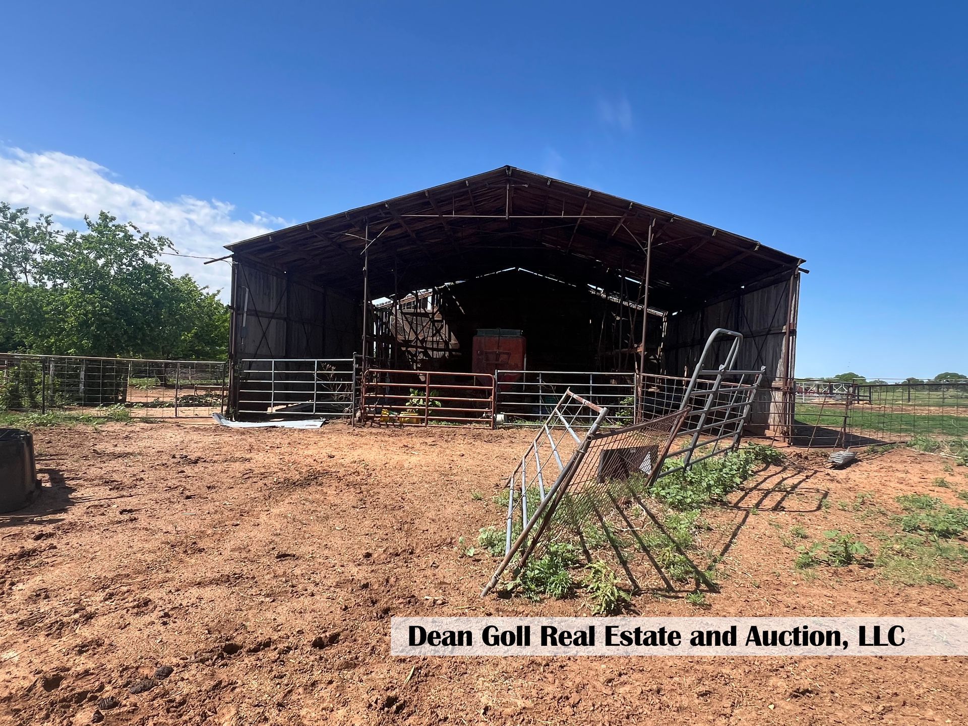 A large barn in the middle of a dirt field