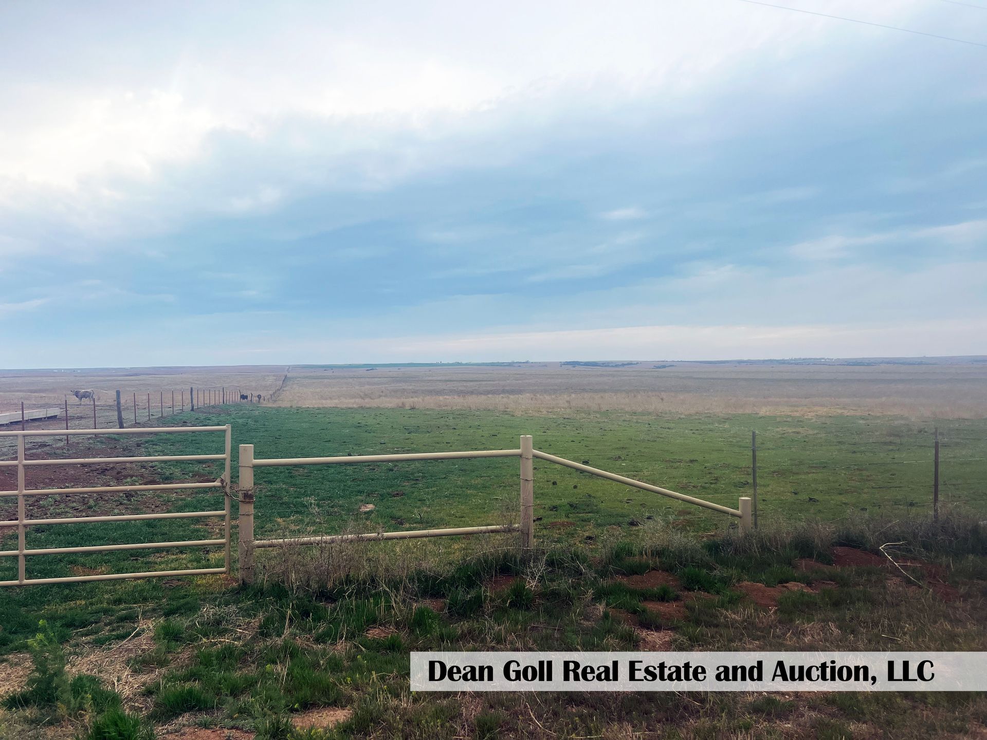 A view of a field featuring a partially constructed fence