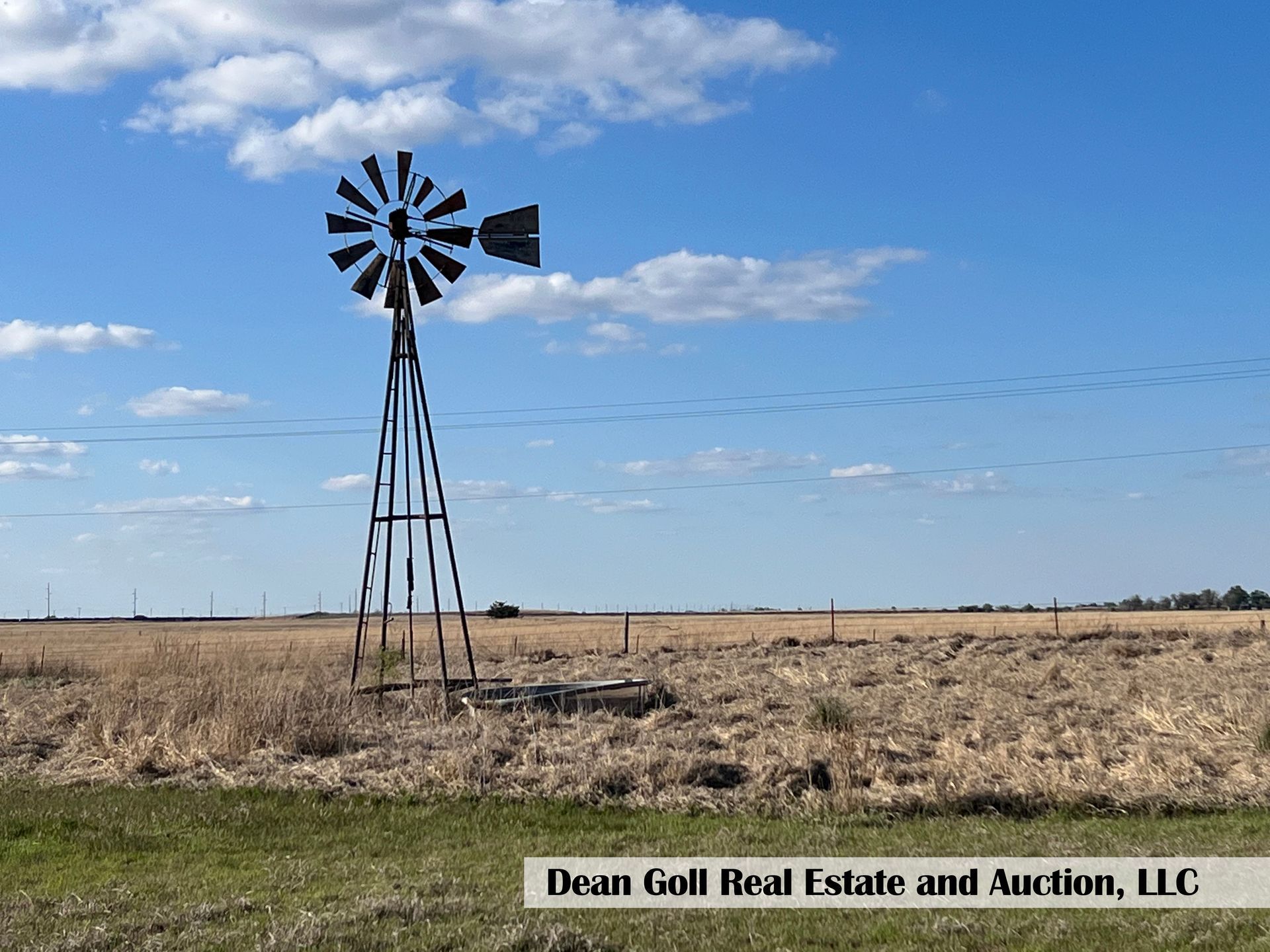 A view of a windmill in the middle of a grassy field