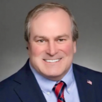Smiling man in suit and striped tie against a gray background