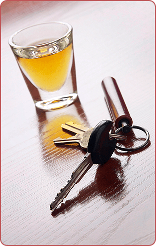 Alcoholic beverage in a shot glass and car keys