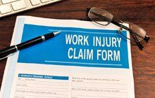 Work injury claim form with pen and an eyeglass