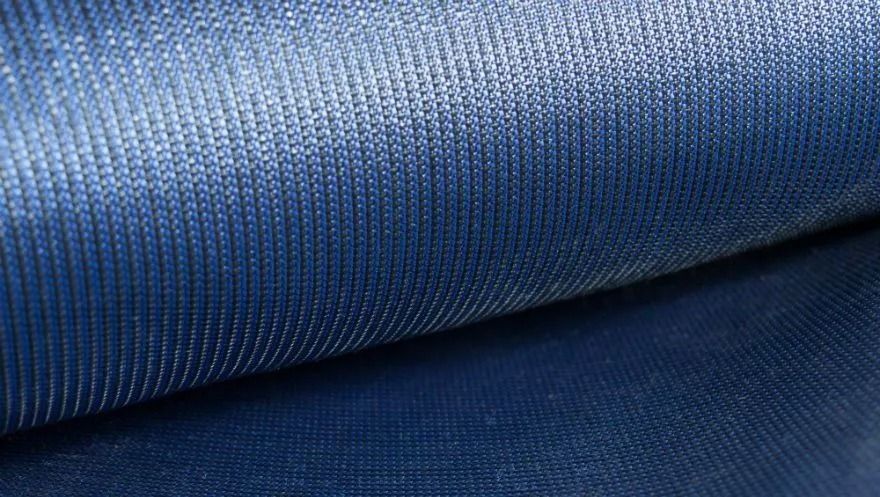 Close-up of blue textured fabric with vertical lines and a slight sheen.