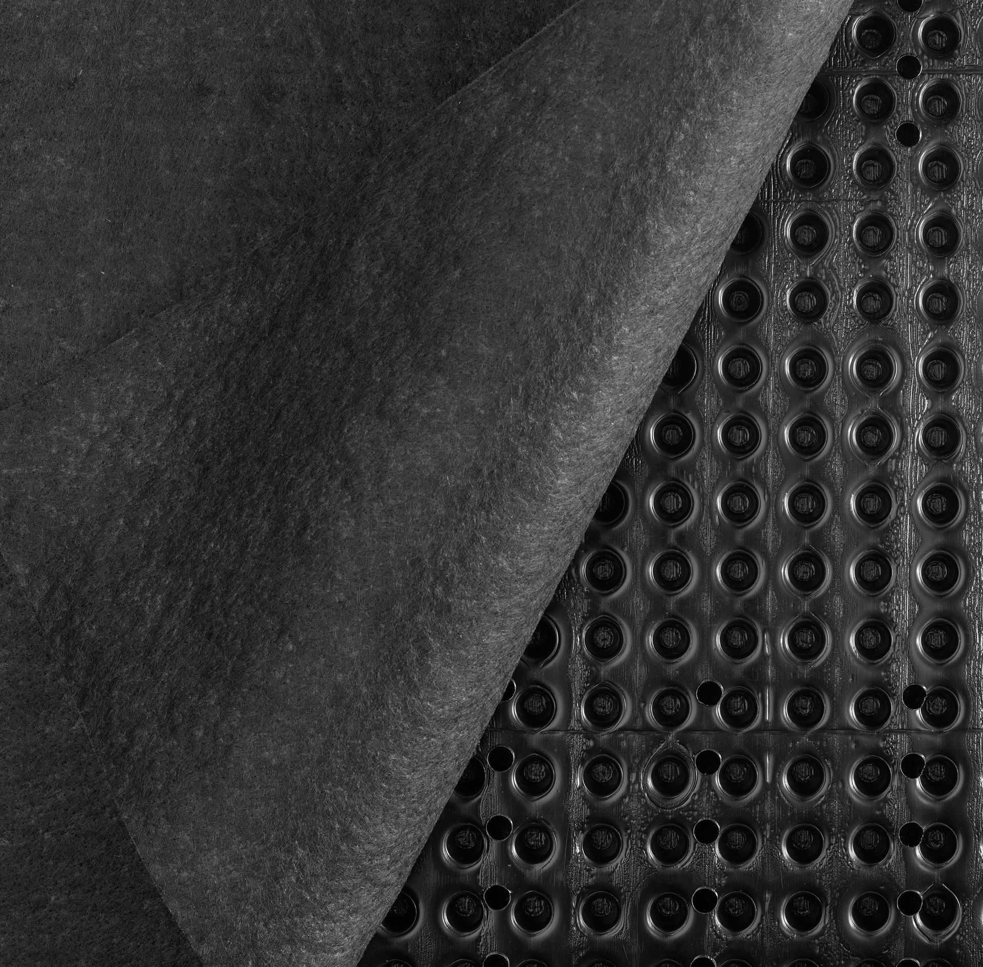 Black drainage membrane with a dimpled core and a geotextile fabric layer.