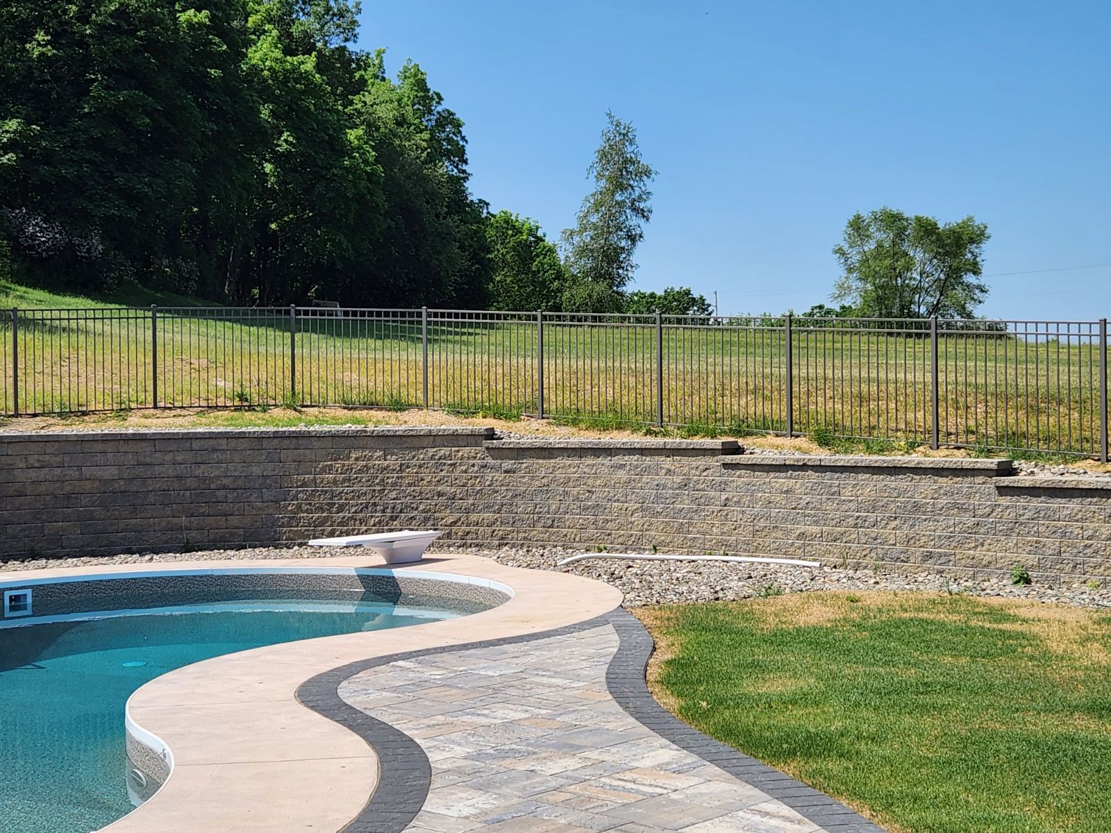 A swimming pool is surrounded by a fence