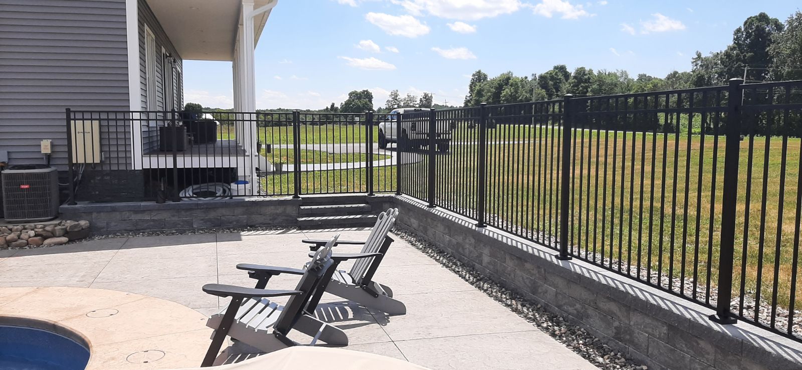 A fenced patio with chairs in front of a house