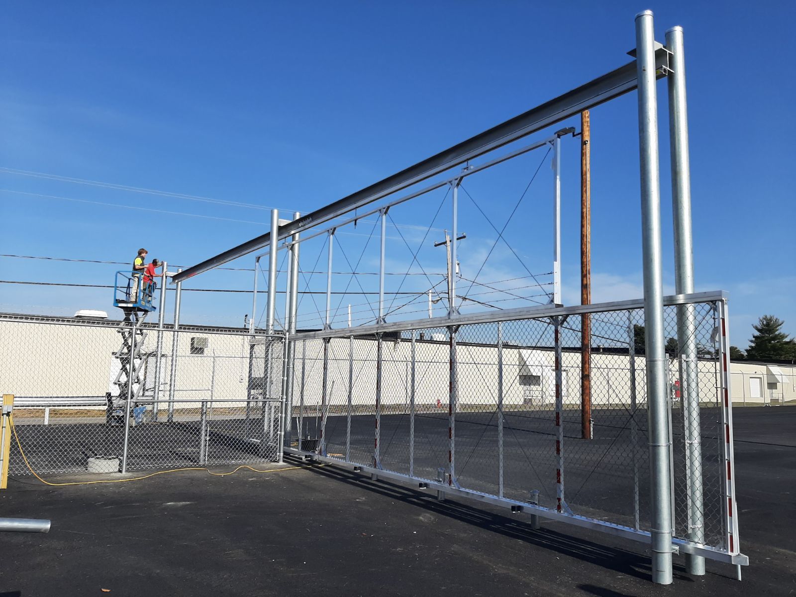 A metal fence is being built in a parking lot