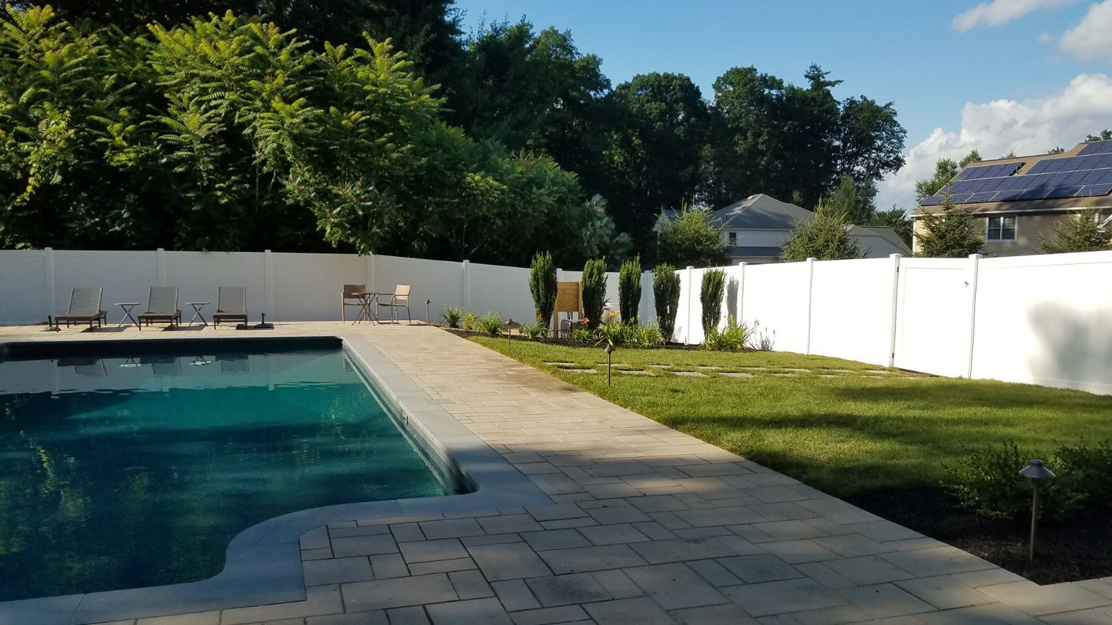 A swimming pool with a white fence surrounding it