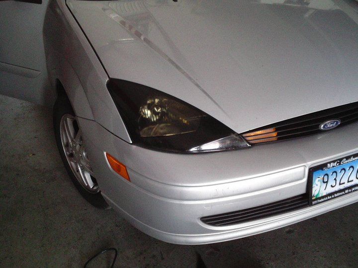 A silver ford car with a license plate that says 9322