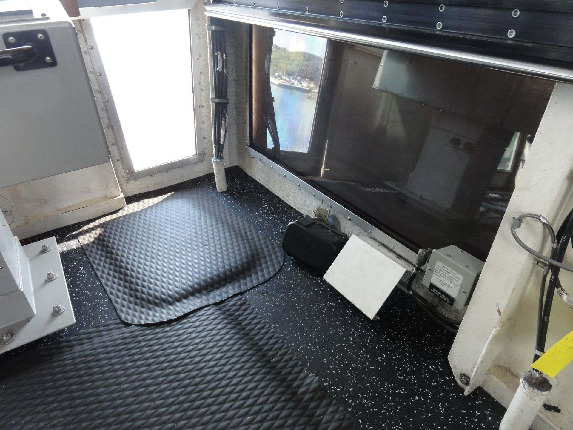 A room with a black mat on the floor and a window