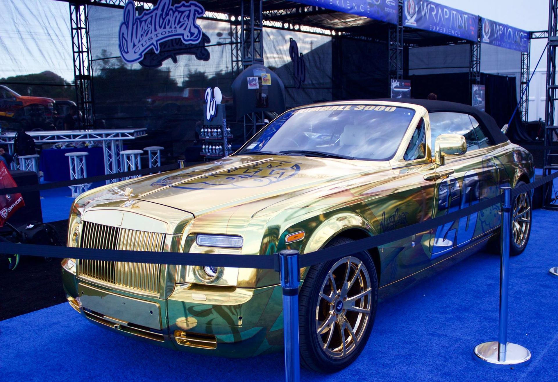 A gold car is parked on a blue carpet