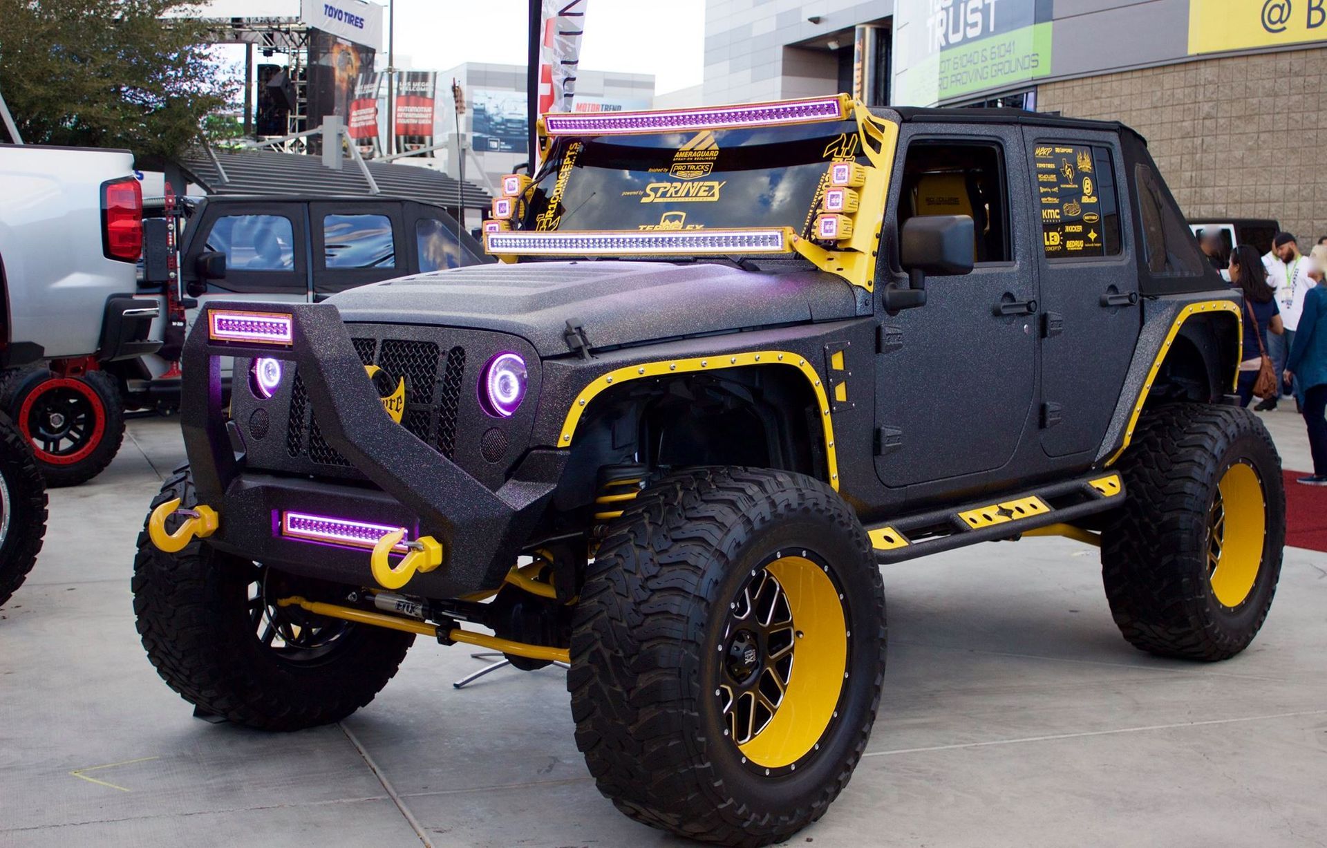 A black and yellow jeep is parked in front of a building