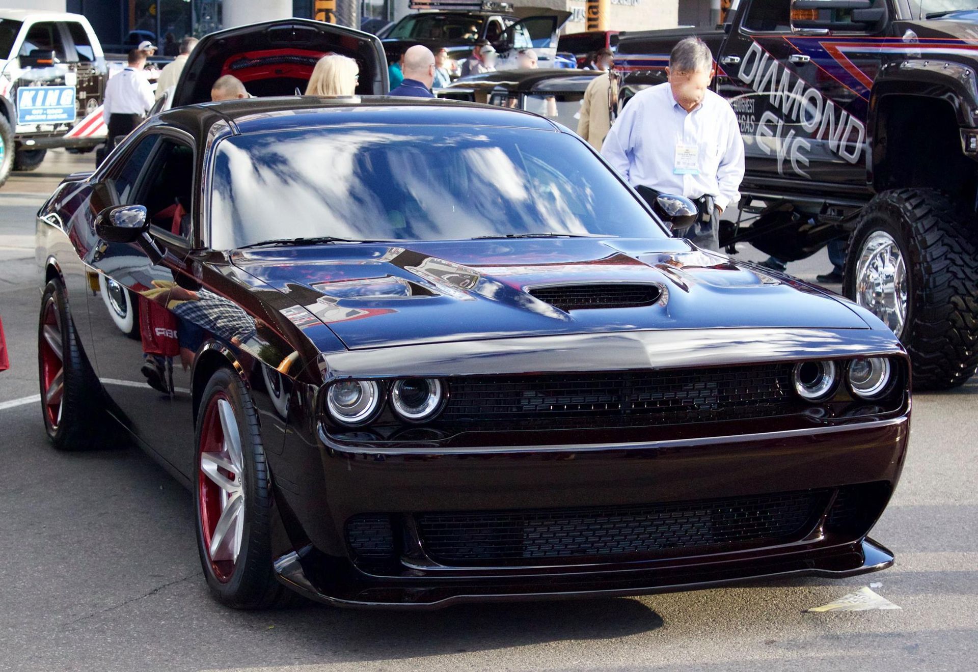 A black dodge challenger is parked on the street