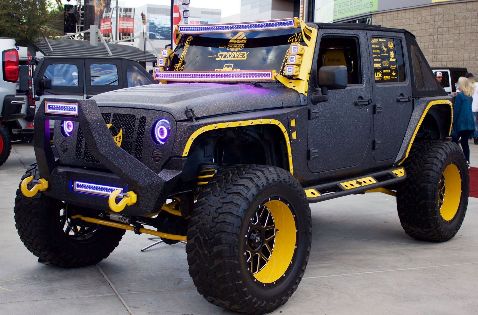 A black and yellow jeep is parked on the side of the road