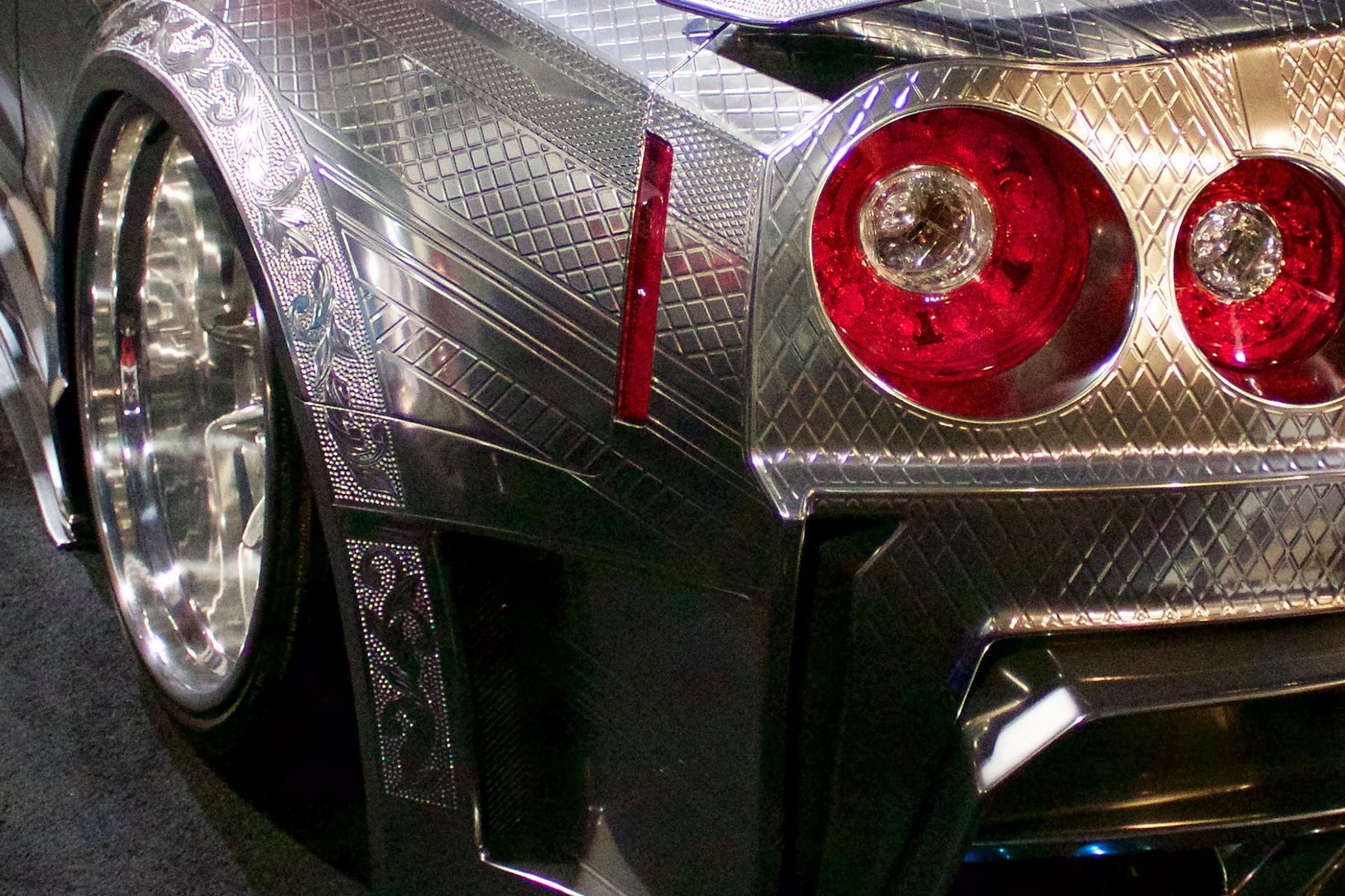 A close up of a silver car with red lights