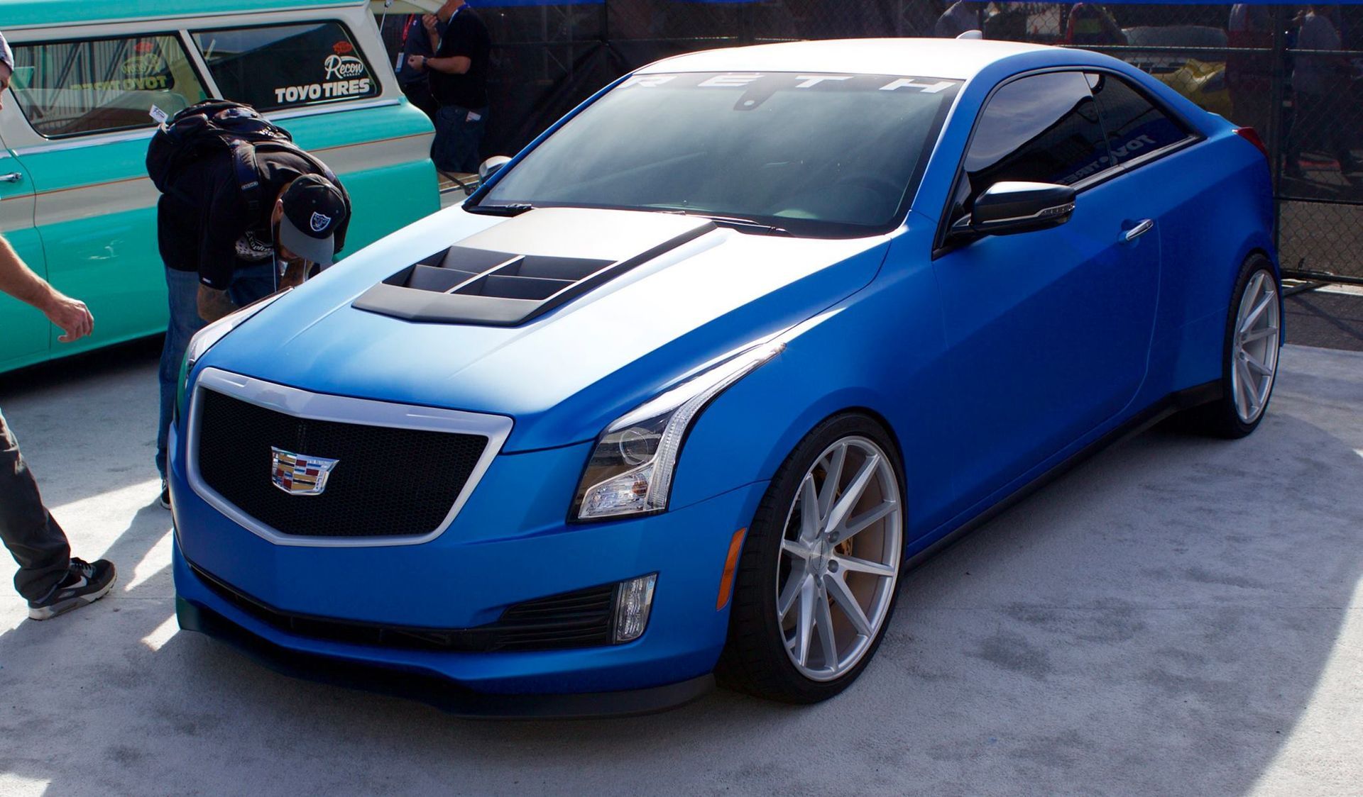 A blue and white cadillac is parked in the snow