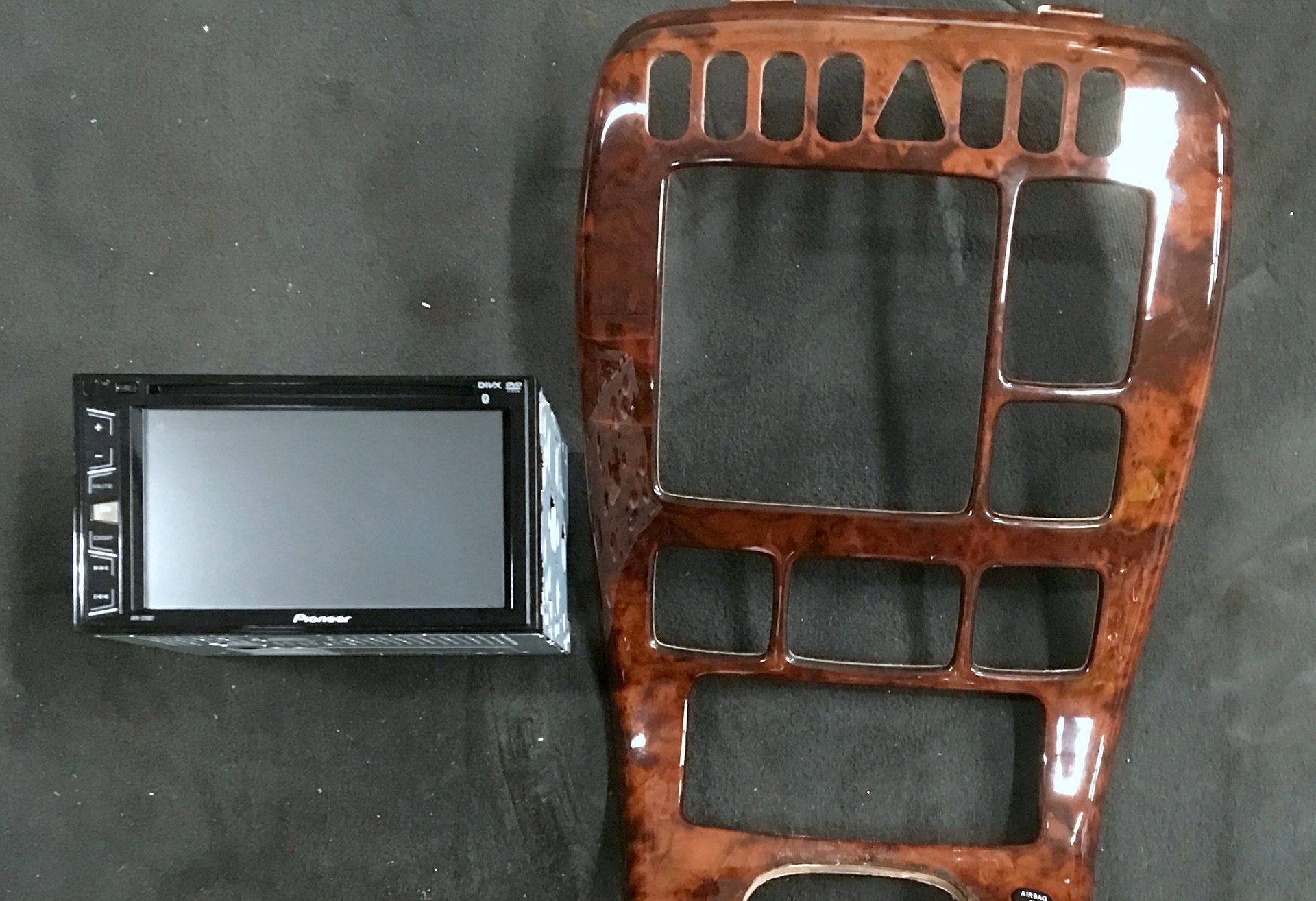 A pioneer radio sits next to a wooden dashboard