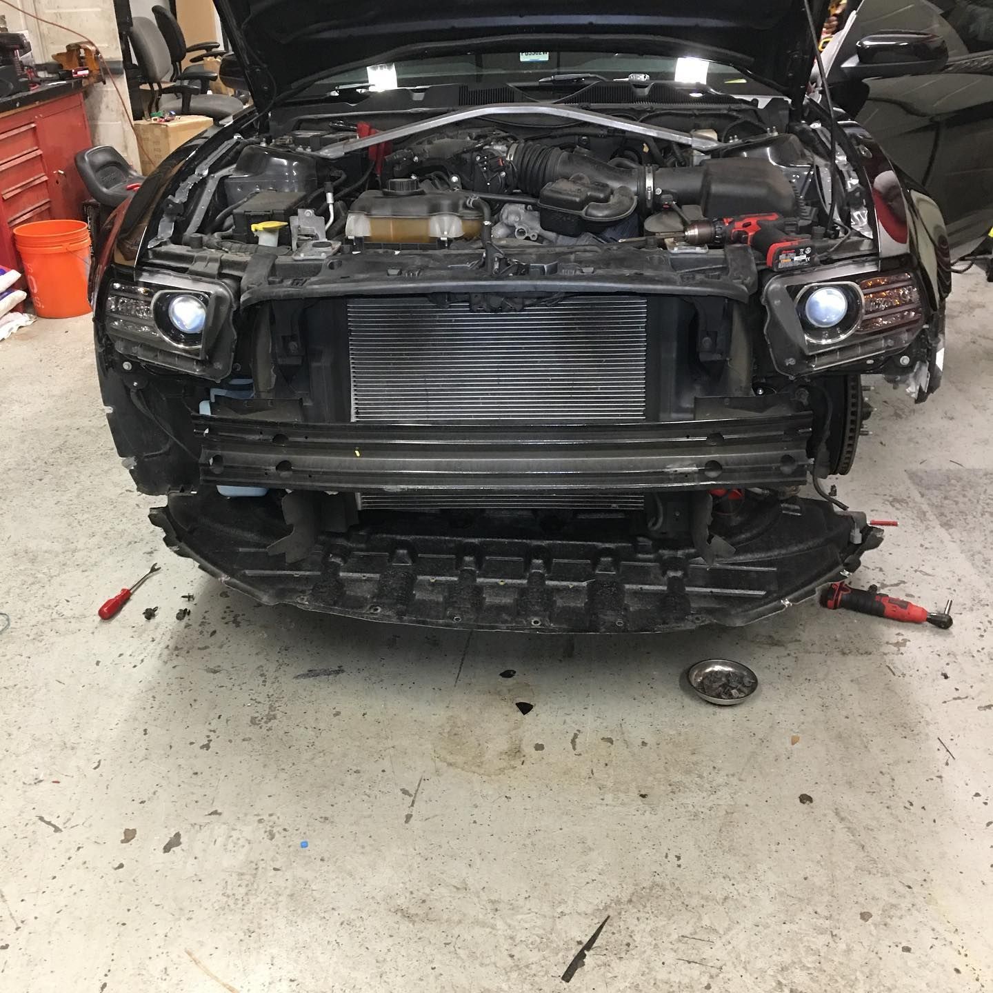 A black car is being worked on in a garage