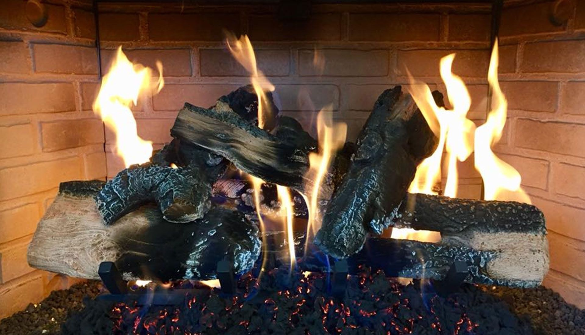 A fireplace filled with logs and flames.