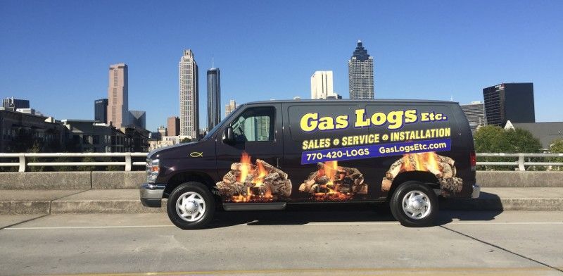 A gas logs van is parked on the side of the road.
